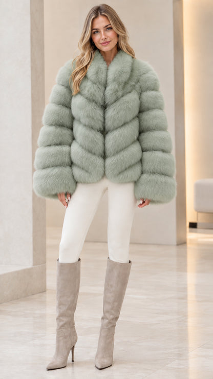 Model wearing soft sage green chevron faux fur coat with white skinny trousers