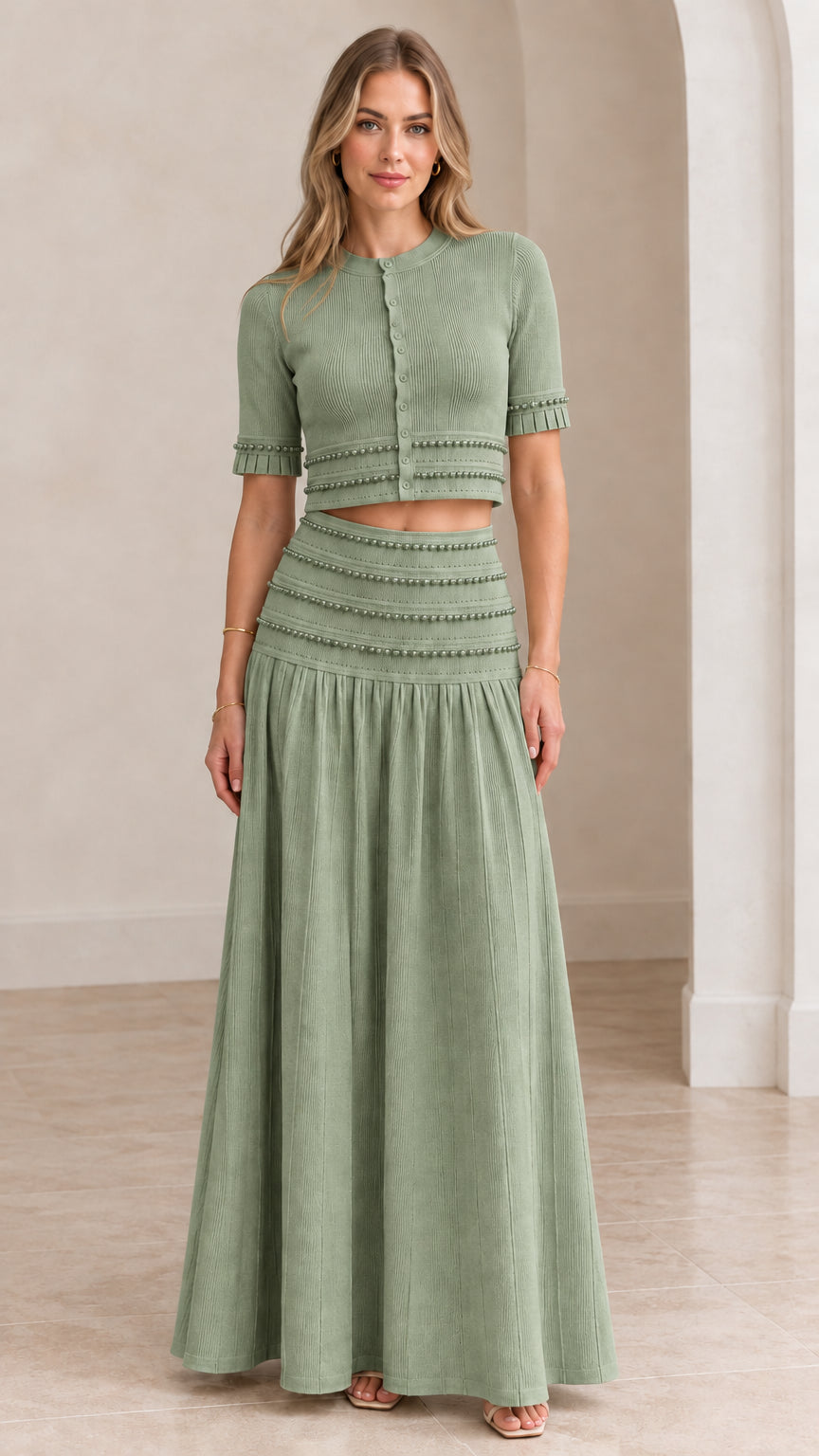 Model wearing sage green beaded crop top and pleated maxi skirt set