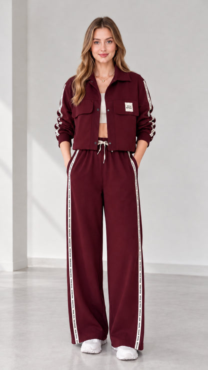 Full view of women's cropped jacket and wide-leg track pants set in burgundy