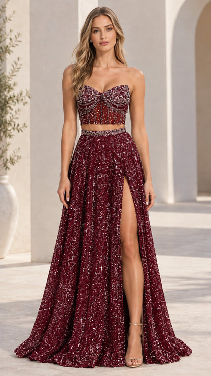Model wearing burgundy red two-piece beaded bustier maxi formal gown