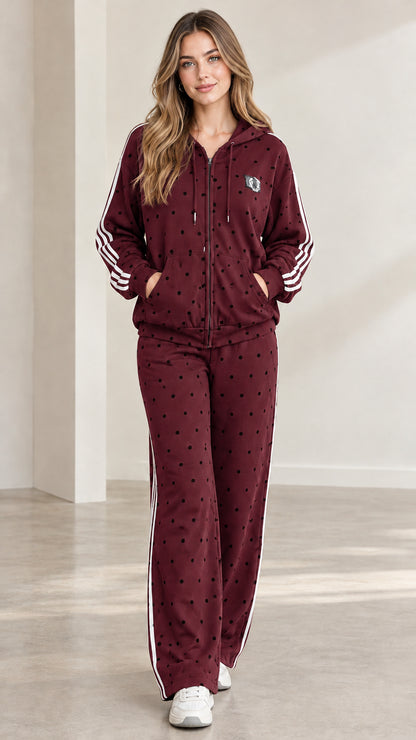 Model wearing deep burgundy polka dot hooded tracksuit set with white side stripes