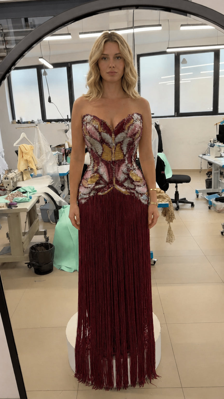 Front view of strapless beaded corset fringe evening gown in burgundy