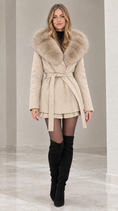 Front view of model wearing beige cream faux fur hooded belted wrap coat with black boots